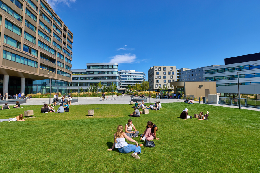 Campus der Hochschule Campus Wien, davor Wiese mit Studierenden
